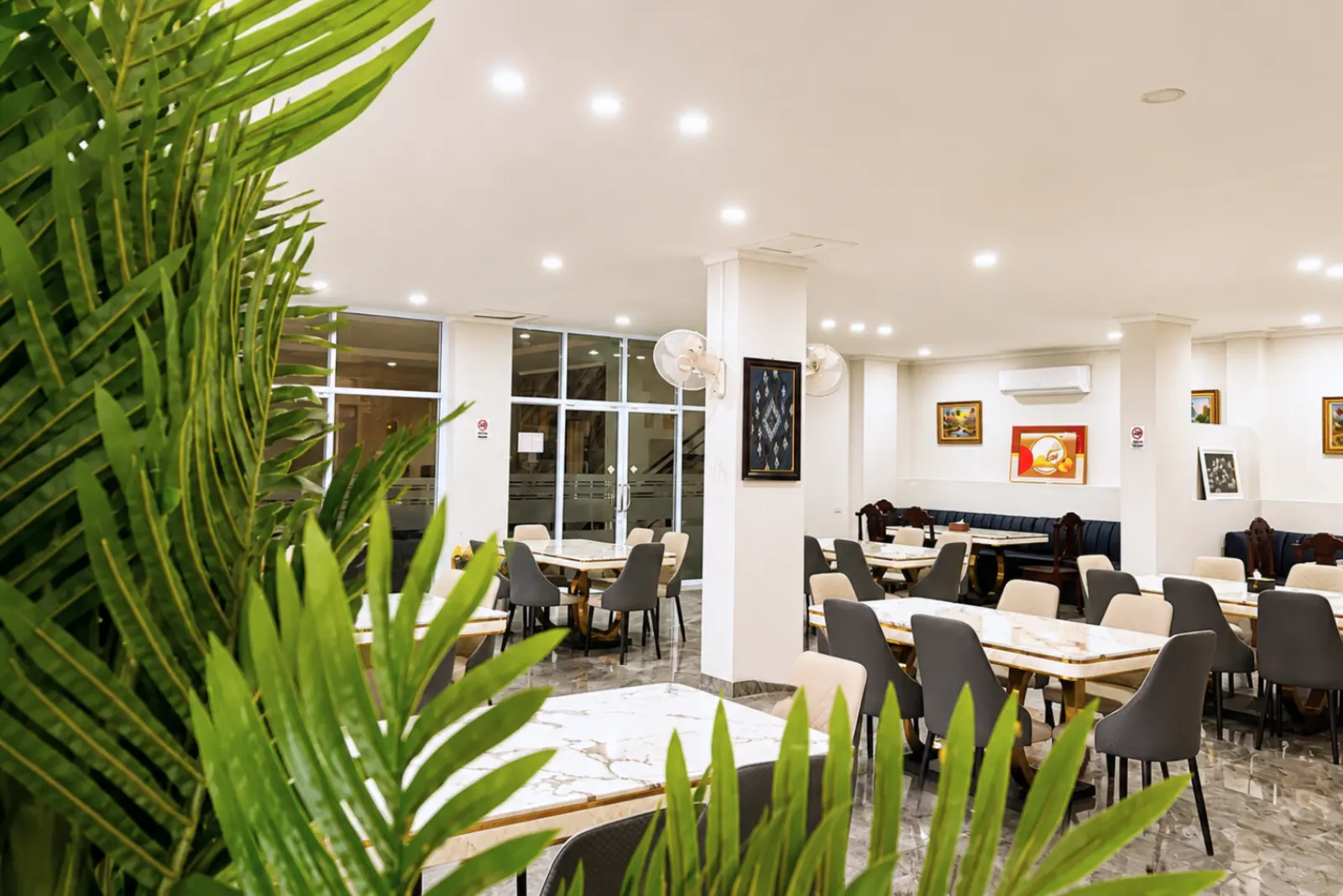 The dining room seen past a palm at the entrance