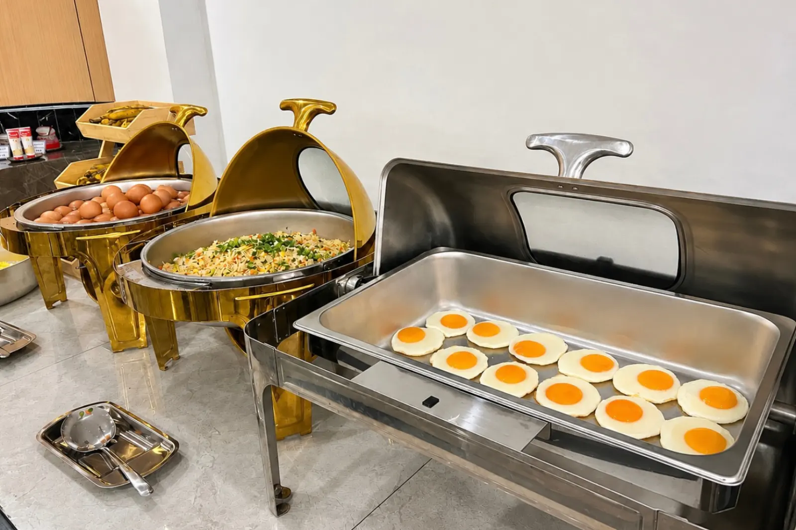 Fried eggs kept warm in a gold chafing dish