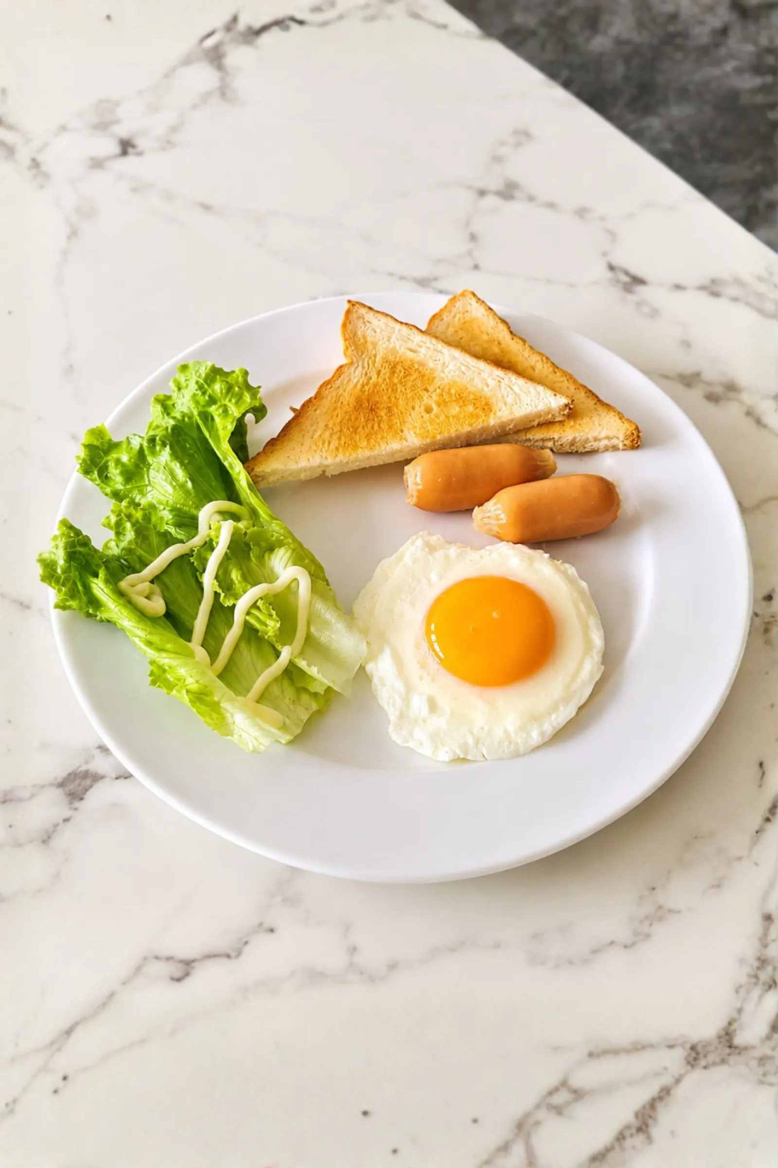 Fried egg with toast, sausage and fresh lettuce