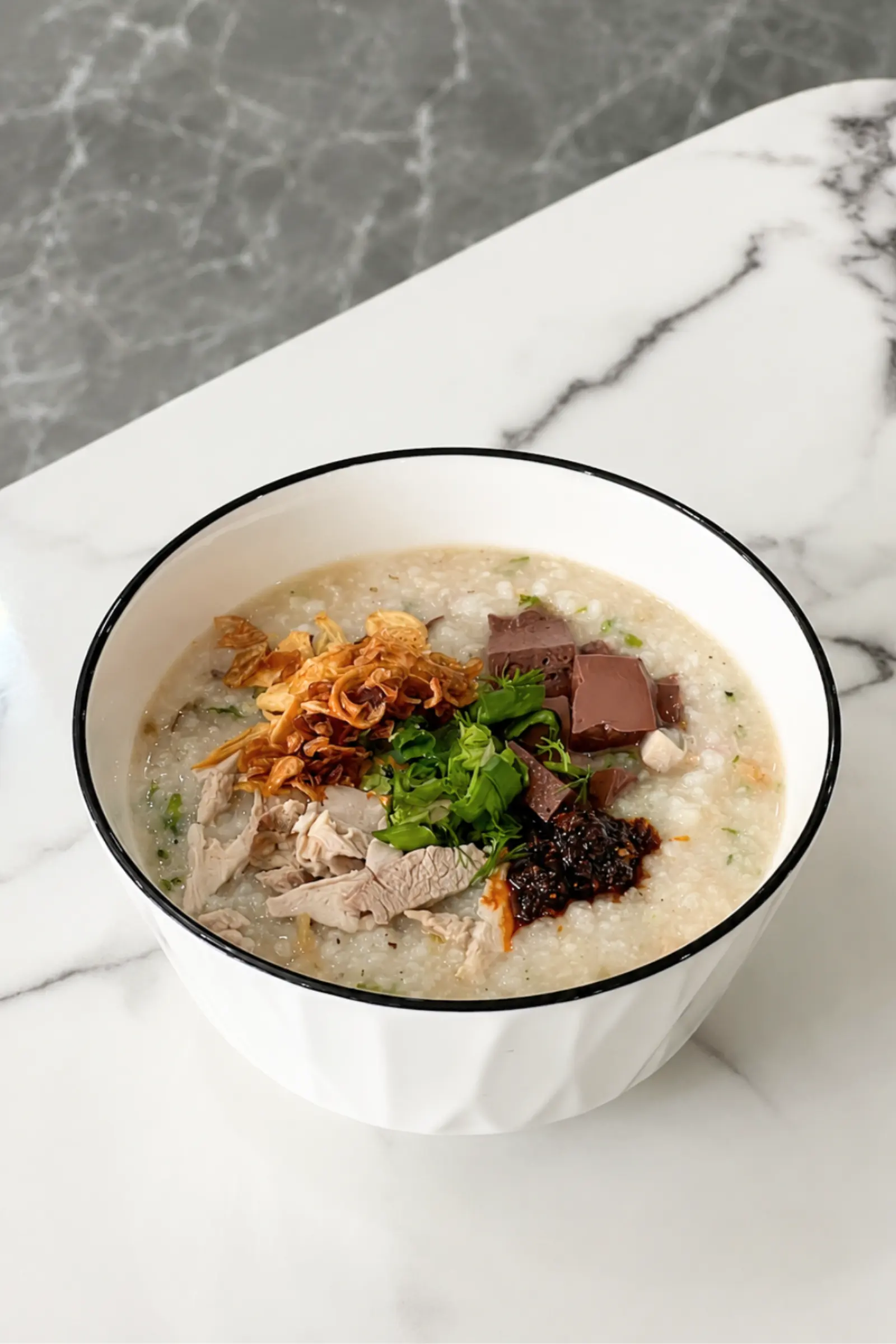 Khao piak khao — rice porridge with pork, herbs and fried garlic