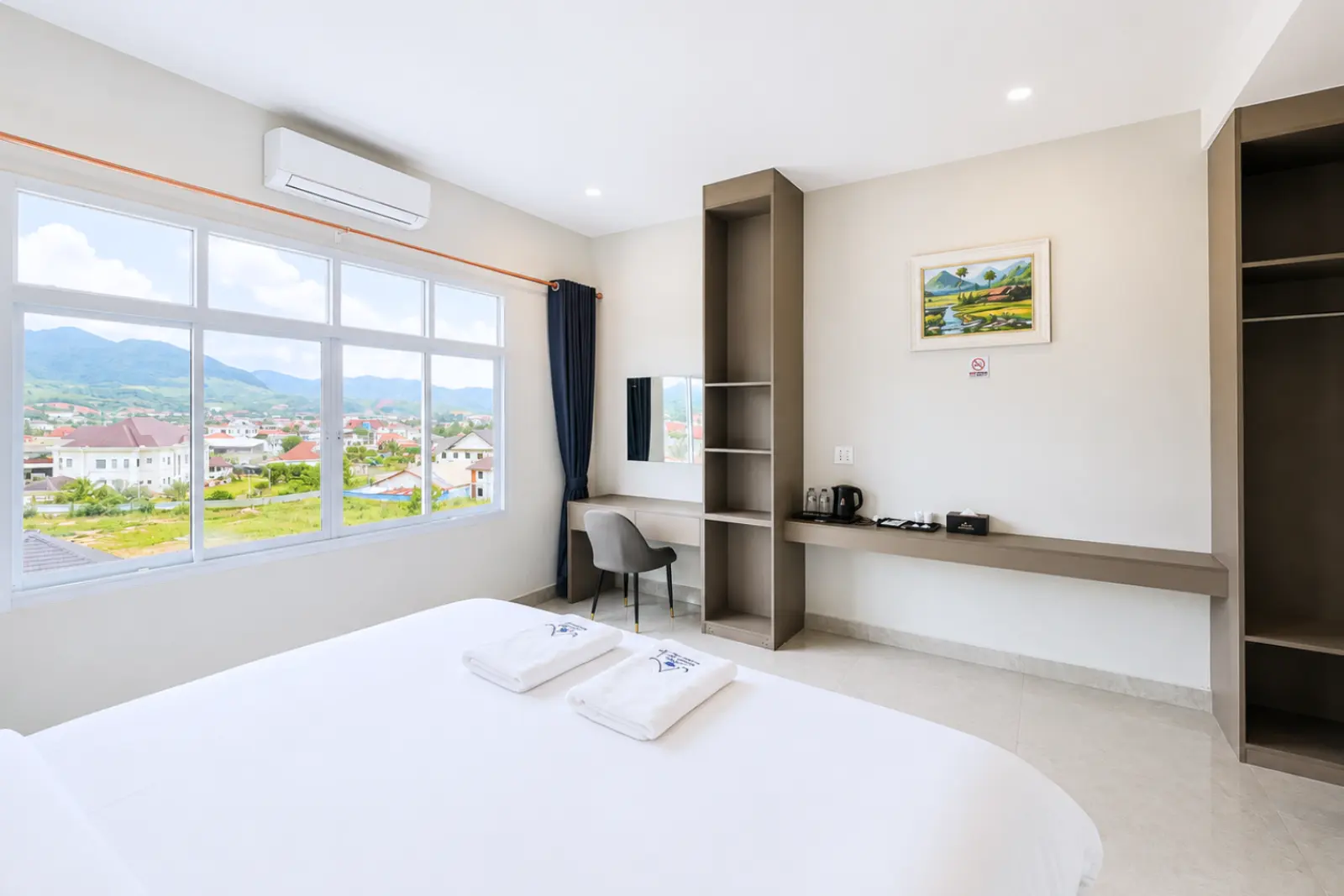 Single room with desk, wardrobe and a window over the town