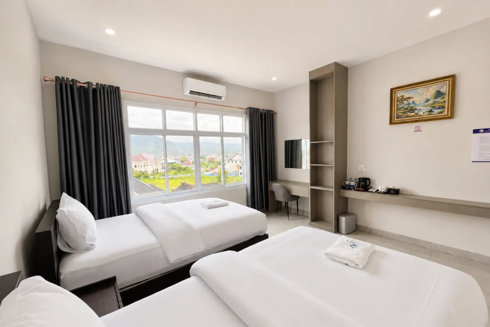 Twin room with two single beds, a work desk and a window over the town