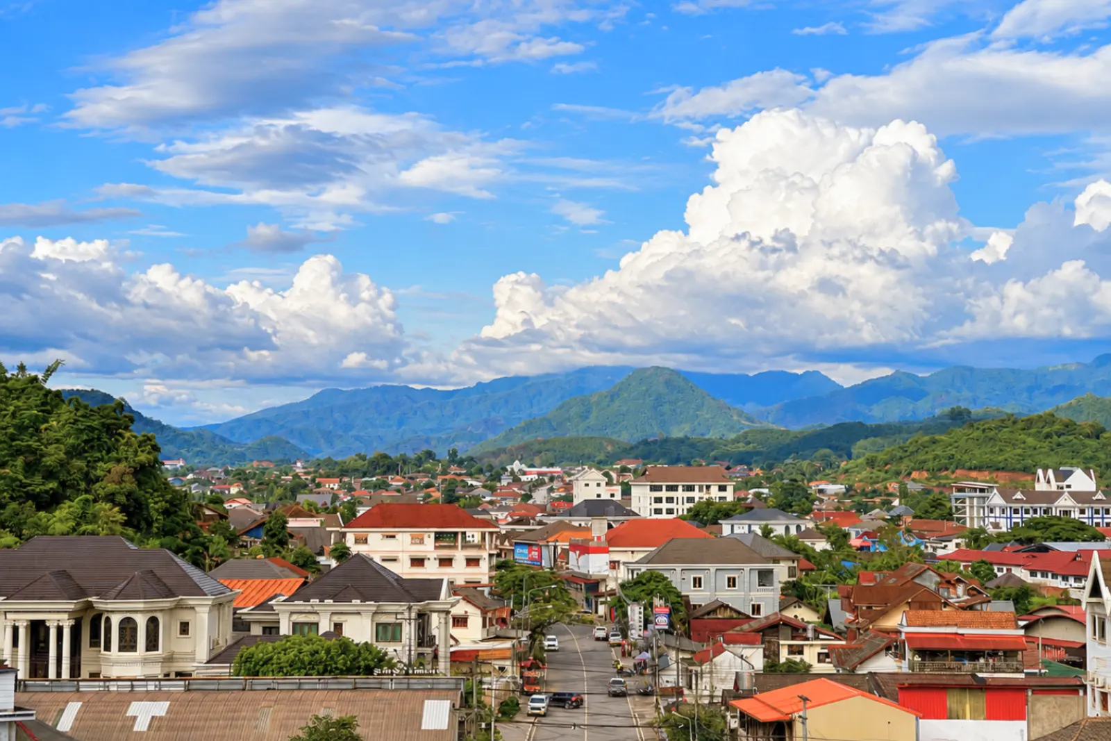 Muang Xai rooftops with the mountain ridge and monsoon clouds behind