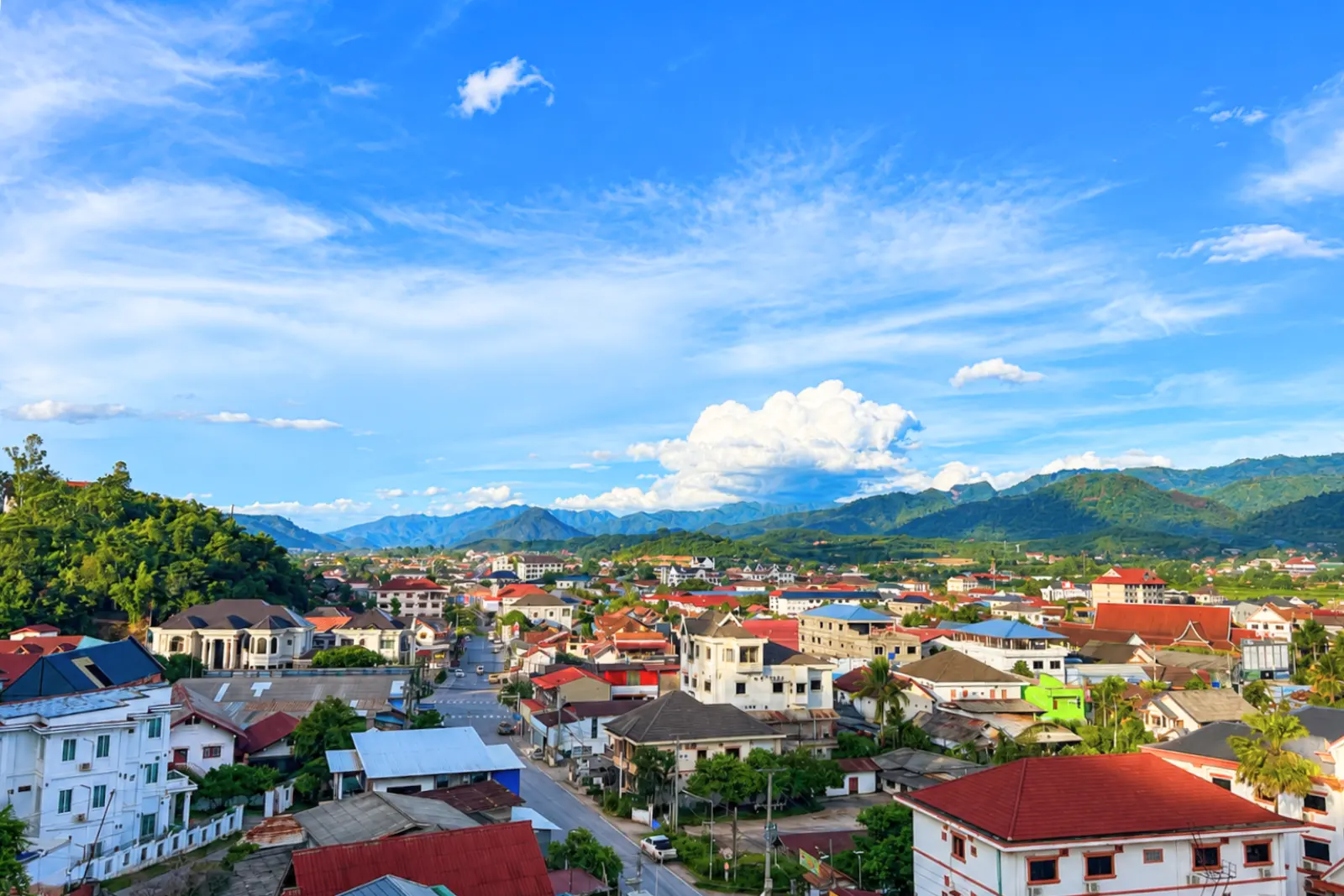 Muang Xai under a wide blue sky, with the hills on every side