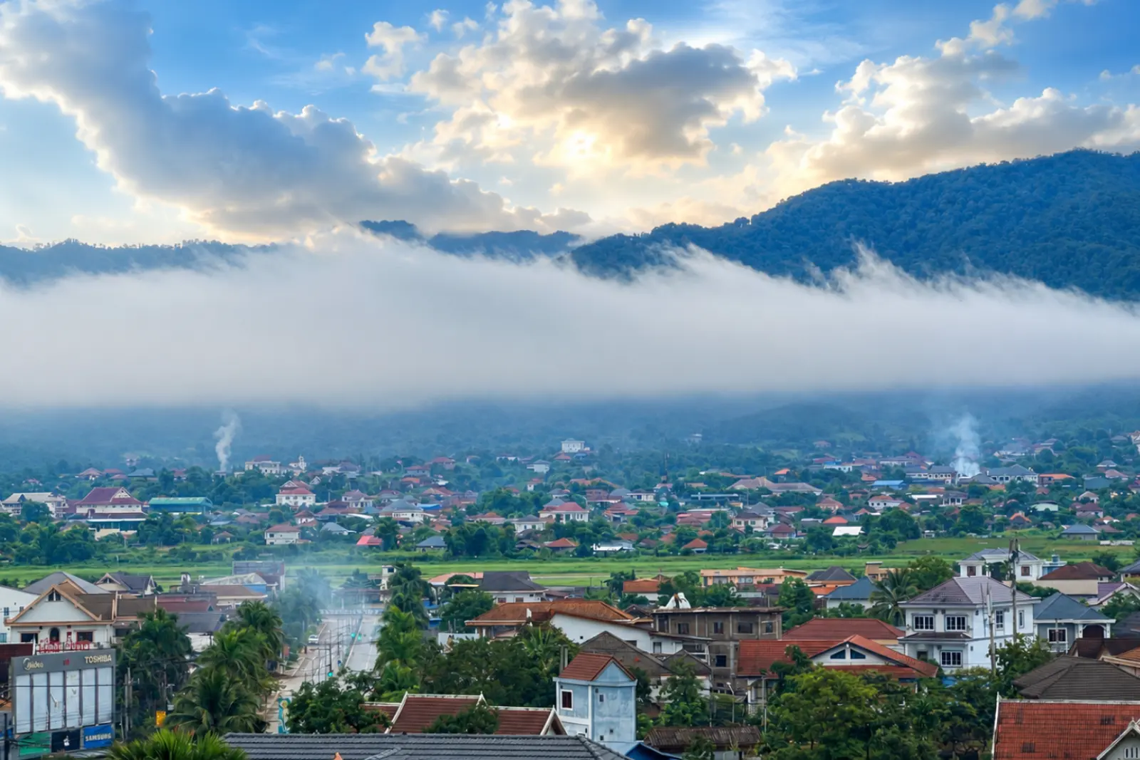 Morning mist rolling off the mountains over the town at sunrise